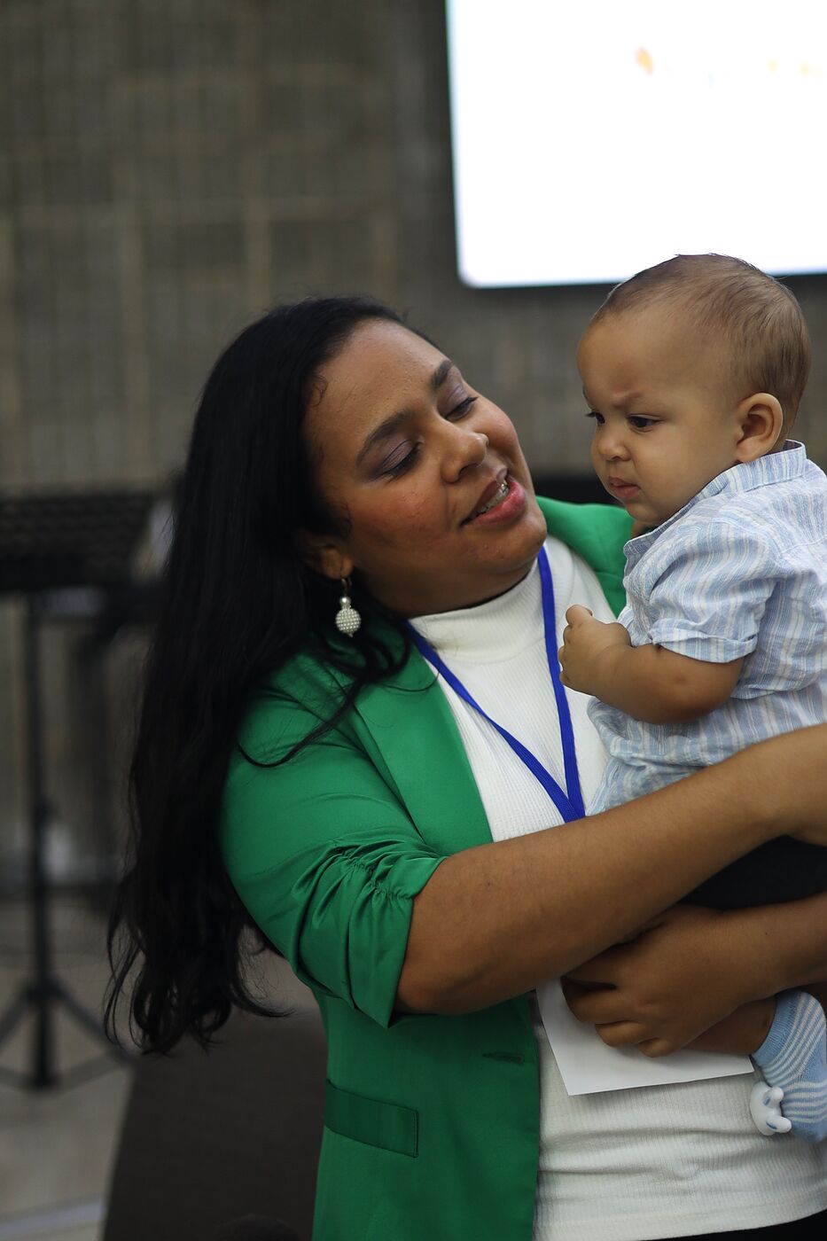 Una madre sostiene a su bebé durante el Prácticum 2026.